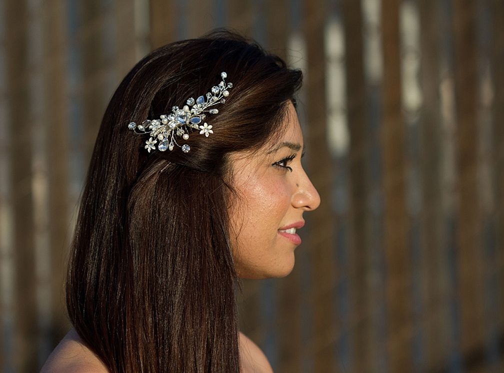 Прическа для свадьбы, которую легко сделать самостоятельно. Прямые темные волосы с белой дорожкой-заколкой с россыпью жемчужин и мелких цветов.
